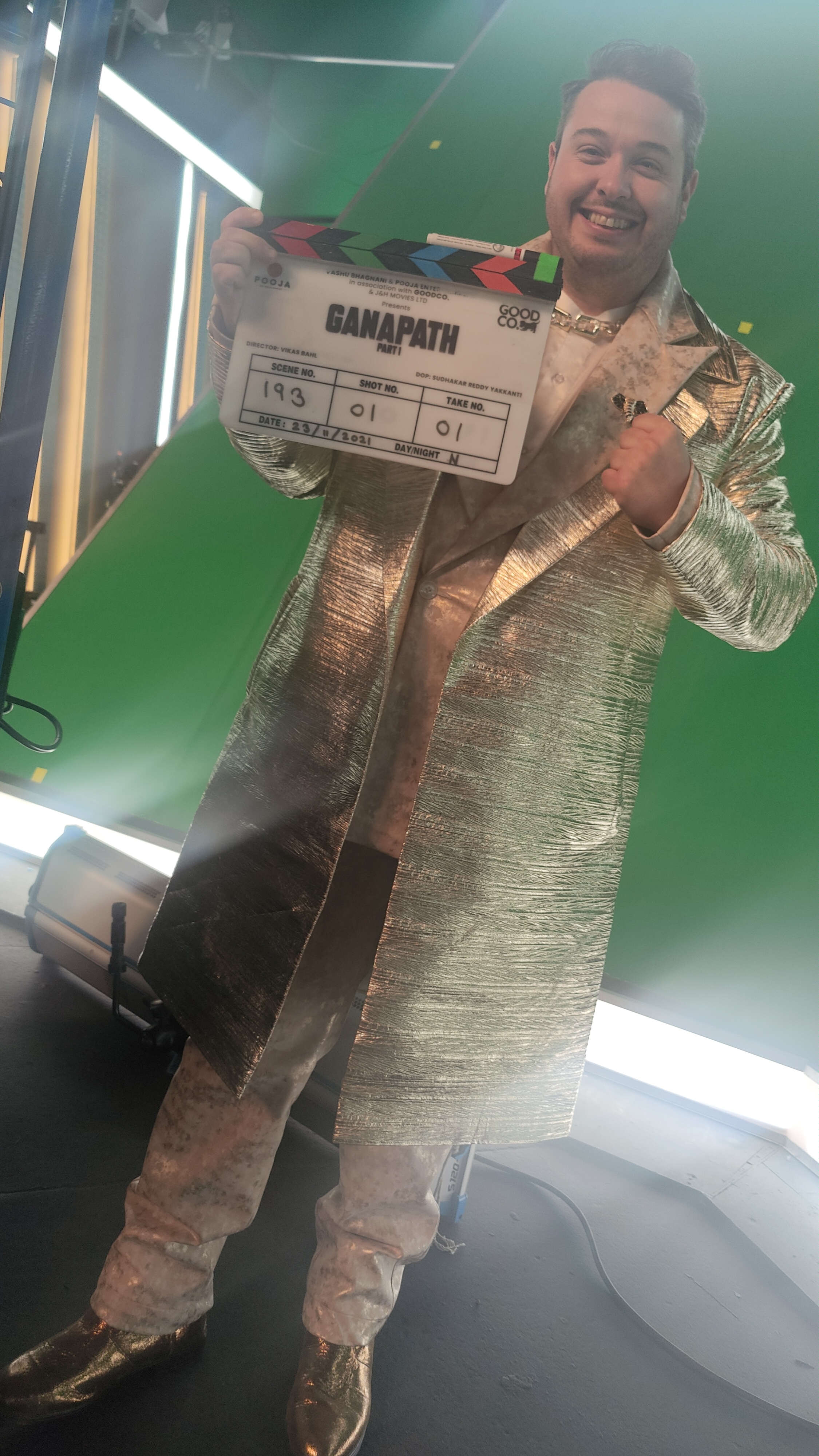 Jonathan Millard on the set of Ganapath holding a clapperboard in costume