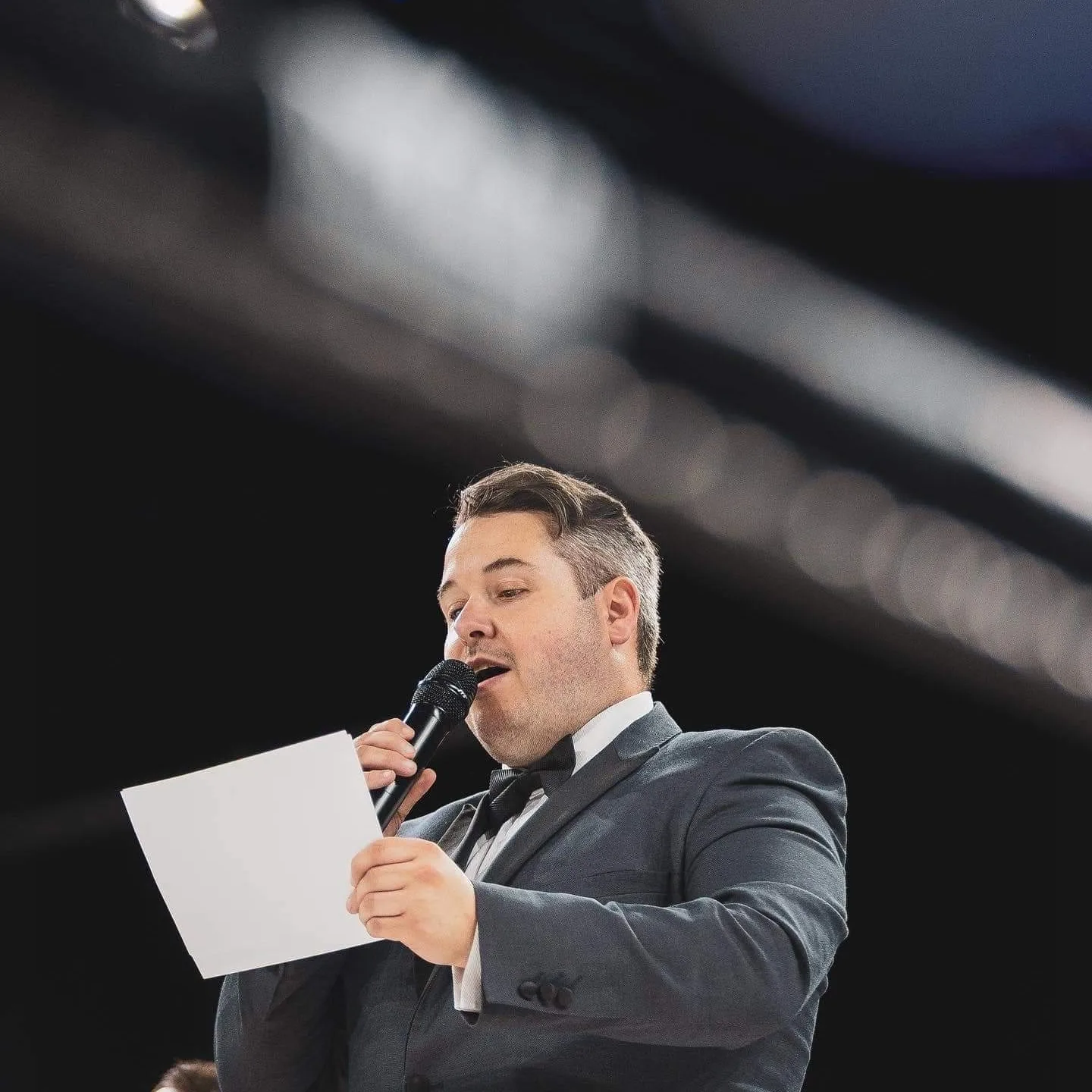 Jonathan Millard delivering a professional announcement on stage
